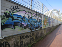 829386 Afbeelding van de graffiti met gestileerde teksten, op het hek langs het fietspad op de Demkaspoorbrug te Utrecht.